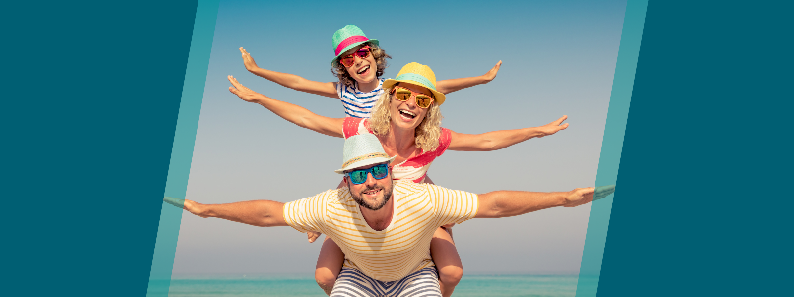 Family of three at a beach, with arms outstretched