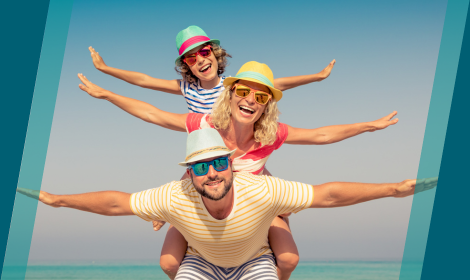 Family of three at beach with arms outstretched